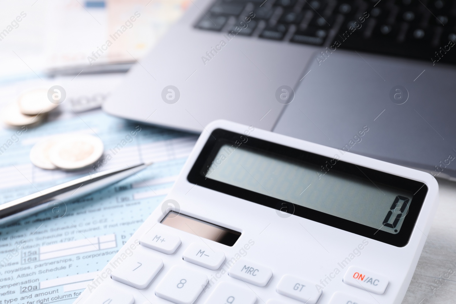 Photo of Tax accounting. Calculator, money, pen, document and laptop on table, closeup