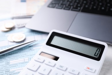 Tax accounting. Calculator, money, pen, document and laptop on table, closeup