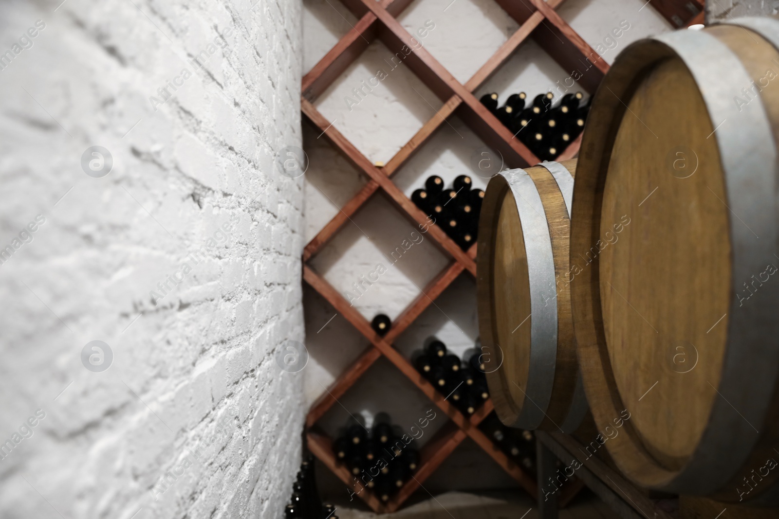 Photo of Wooden barrels on stand in wine cellar, closeup