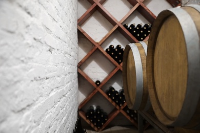 Photo of Wooden barrels on stand in wine cellar, closeup
