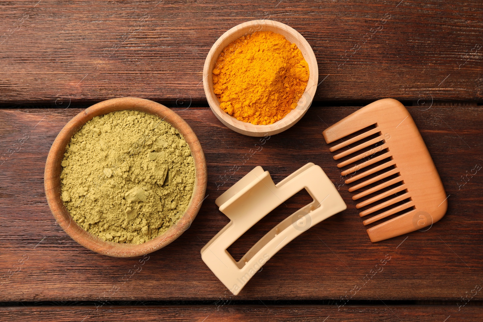 Photo of Hair care products. Comb, hair clip, henna and turmeric powder on wooden table, flat lay