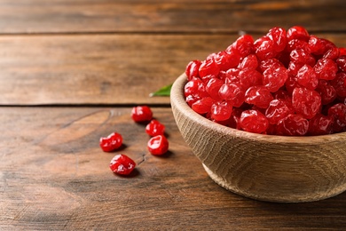 Photo of Bowl with tasty cherries on wooden background, space for text. Dried fruits as healthy food