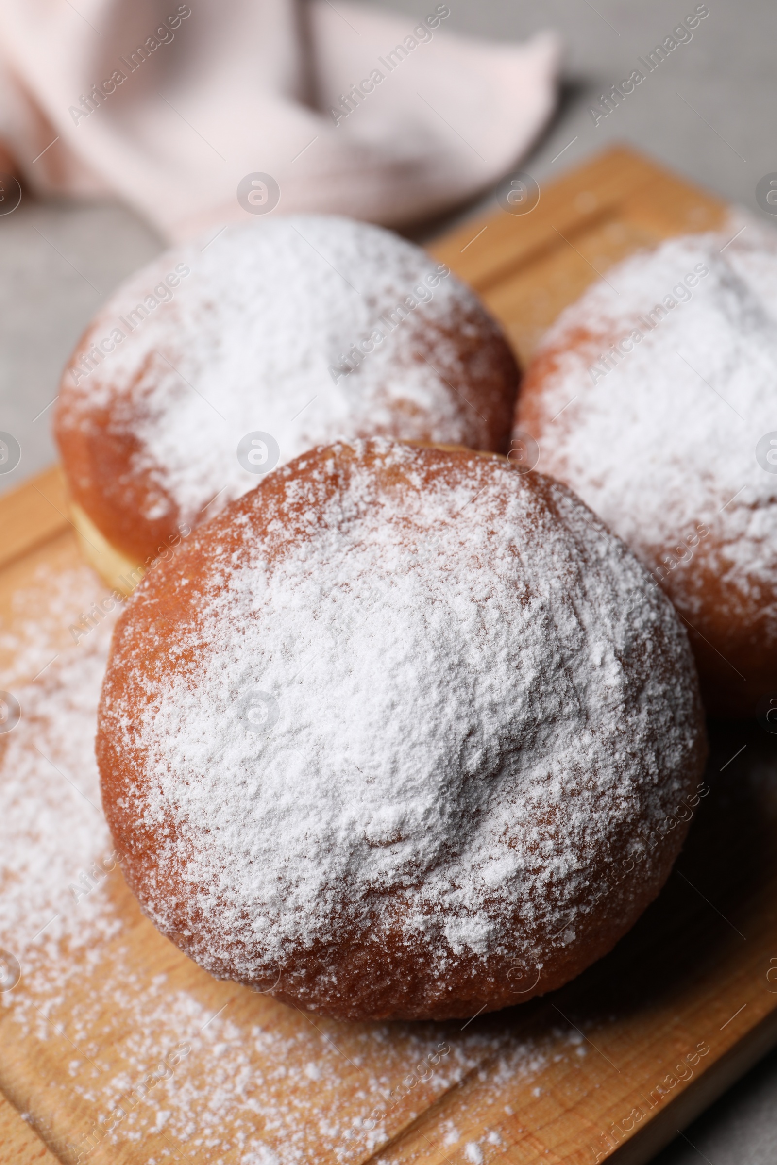 Photo of Delicious sweet buns with powdered sugar on table, closeup