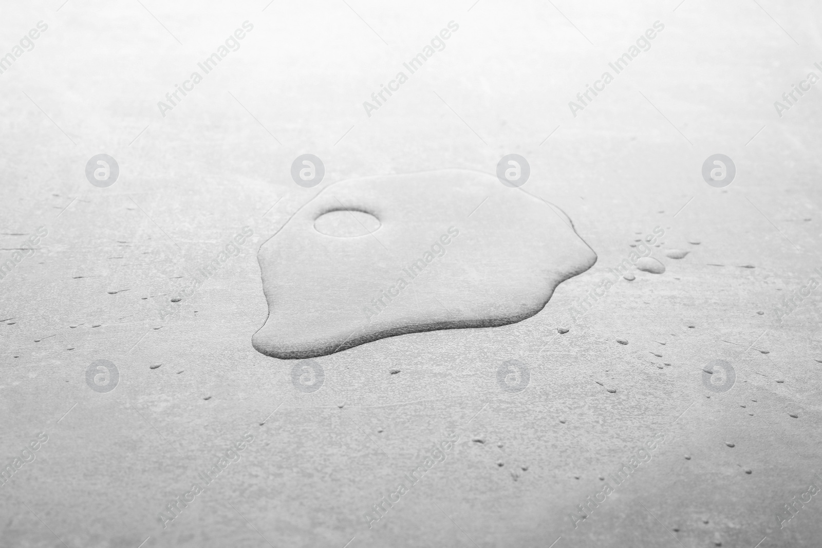Photo of Puddle of water on light grey surface