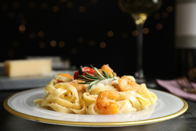 Delicious pasta with shrimps on black table