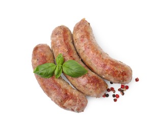 Photo of Tasty homemade sausages, peppercorns and basil leaves isolated on white, top view