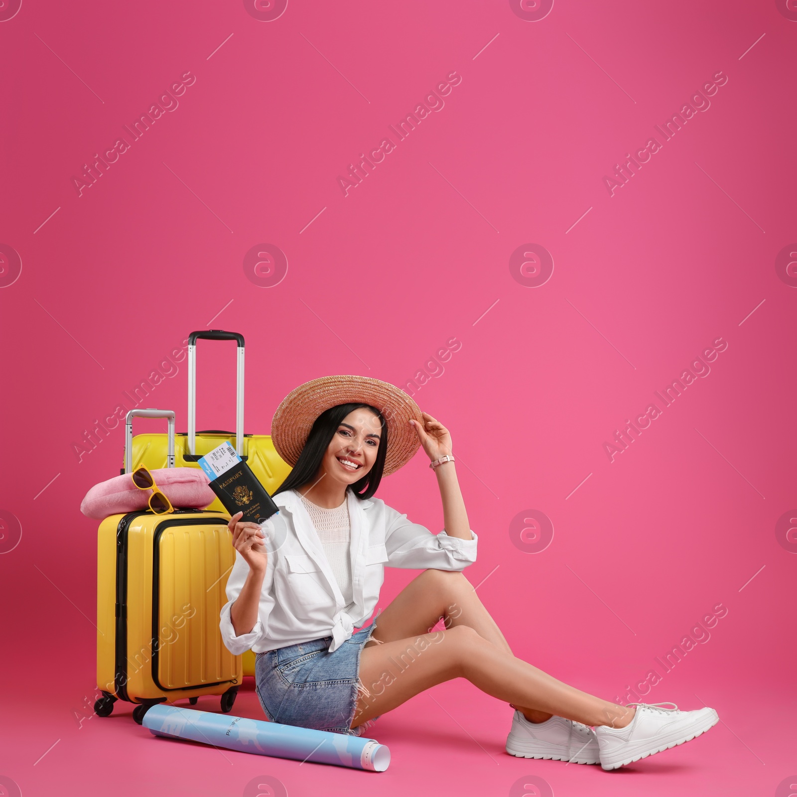 Photo of Female tourist with ticket, passport and travel accessories on pink background
