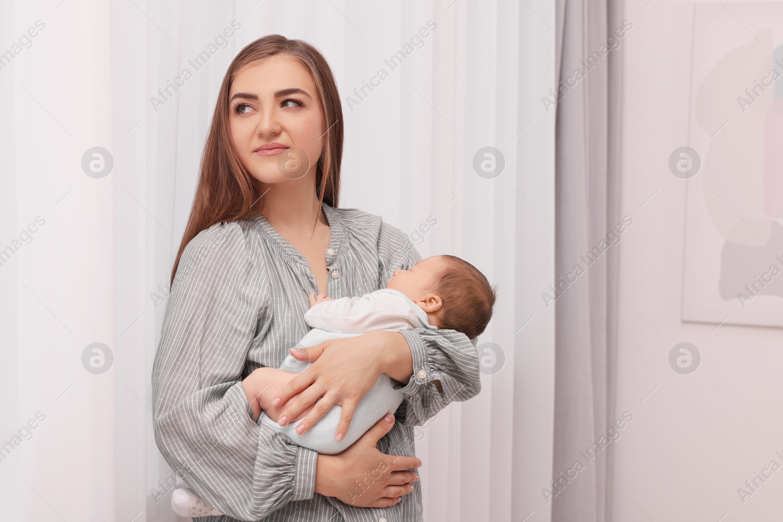 Photo of Mother with her cute newborn baby indoors. Space for text