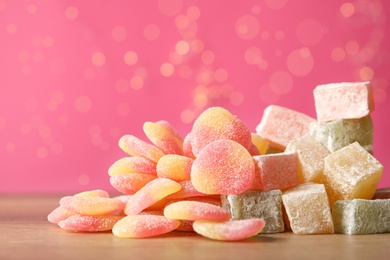 Photo of Pile of tasty sweets on wooden table, closeup. Space for text