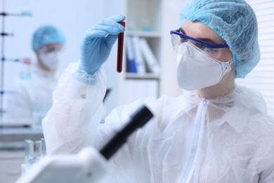 Photo of Scientist working with sample in test tube in laboratory