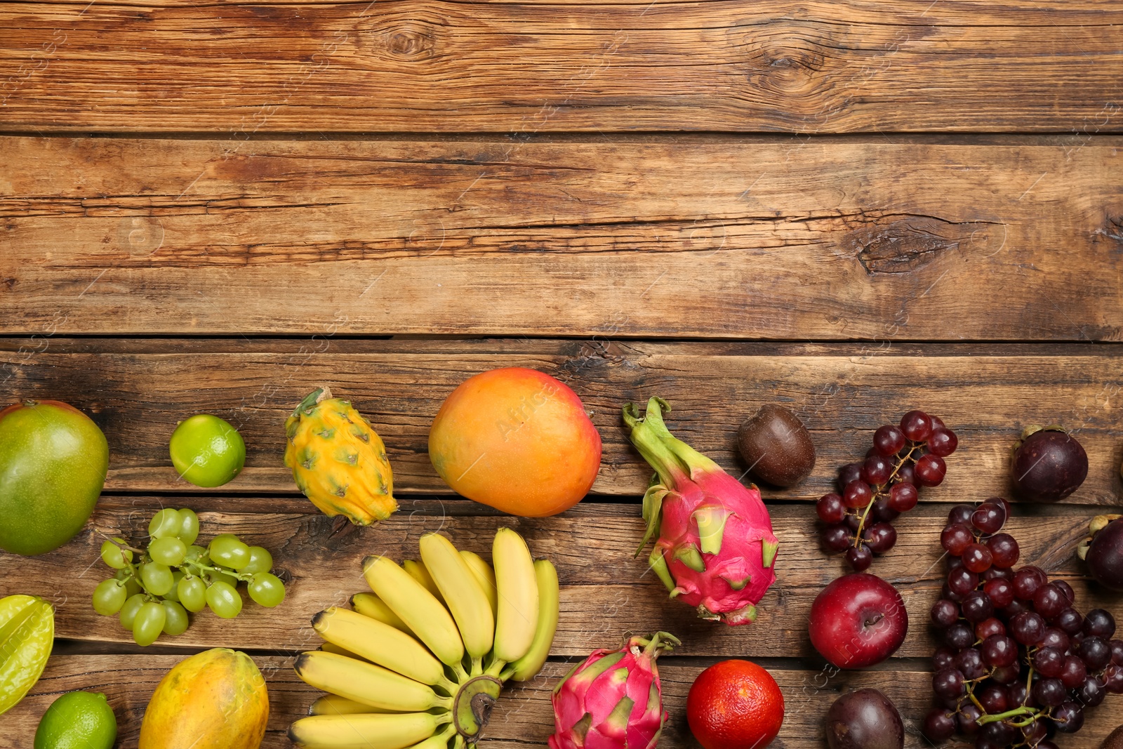 Photo of Many different delicious exotic fruits on wooden table, flat lay. Space for text