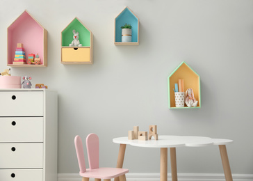 Photo of Children's room interior with house shaped shelves and little table