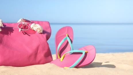 Stylish beach accessories on sand near sea. Space for text