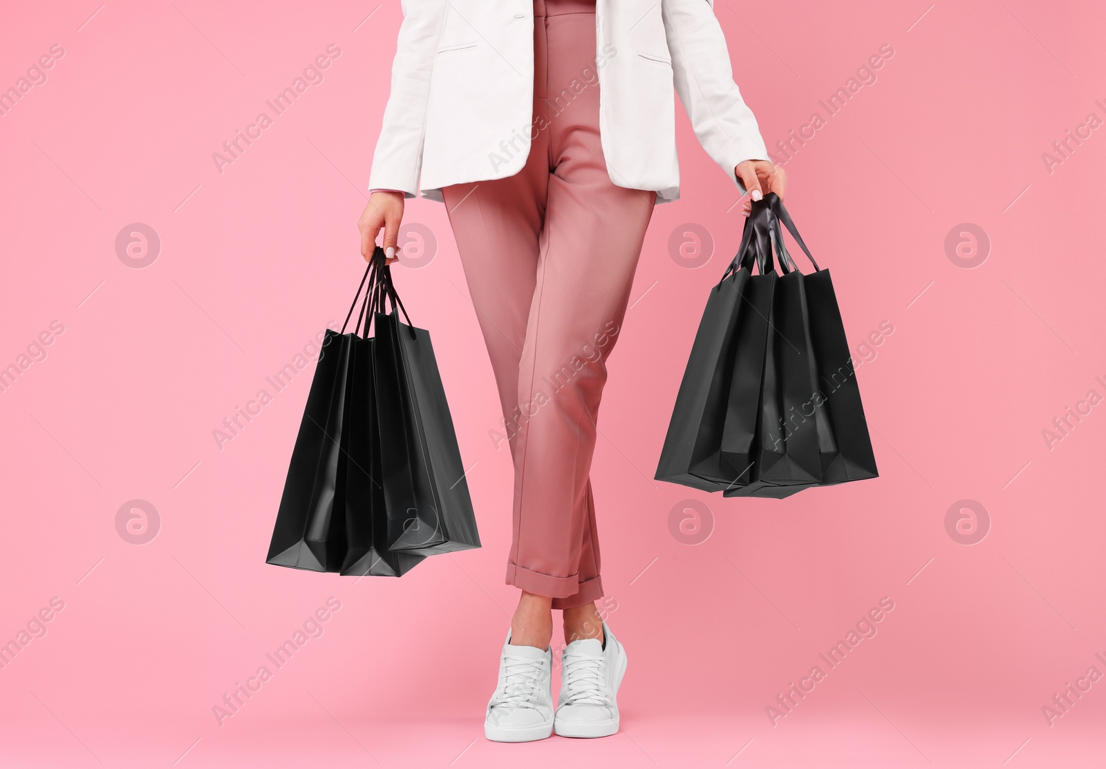 Photo of Woman with shopping bags on pink background, closeup