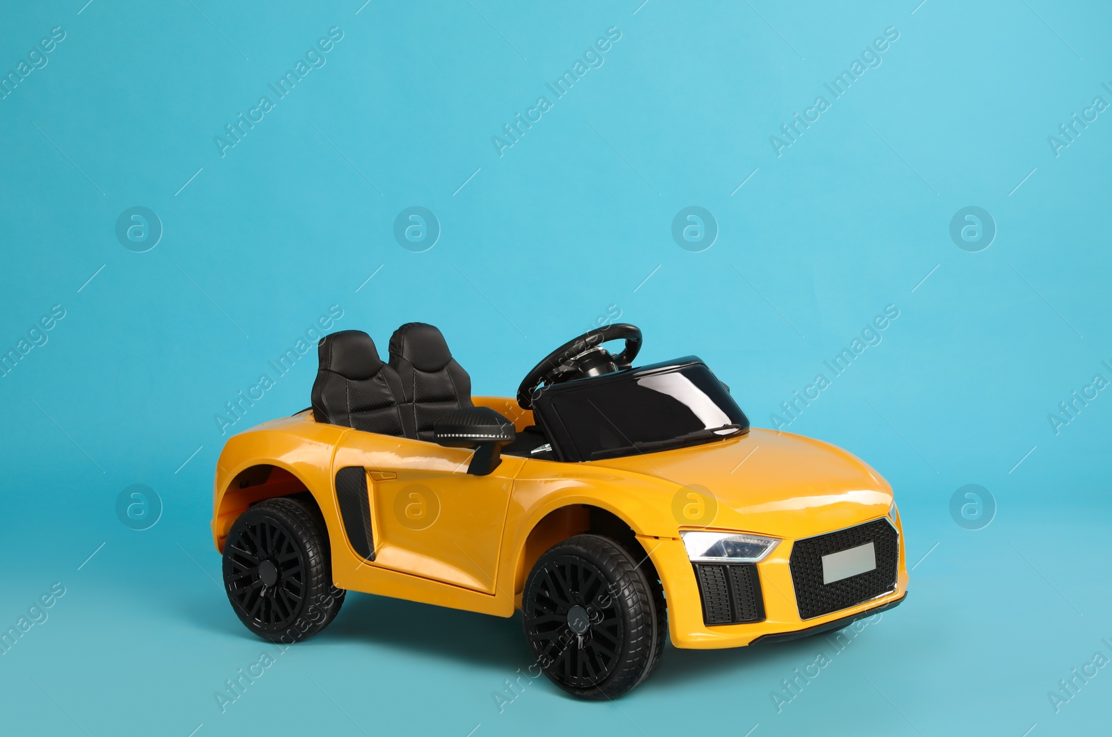 Photo of Small yellow car on light blue background. Children's toy