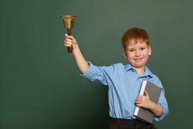 Photo of Pupil with school bell near green chalkboard. Space for text