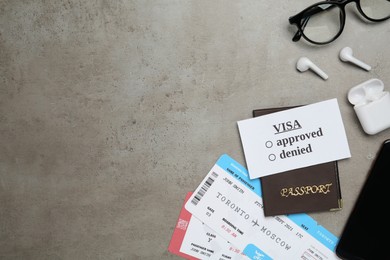 Photo of Flat lay composition with passport, tickets and glasses on grey table, space for text. Visa receiving