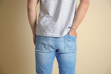 Photo of Young man in stylish jeans on light background