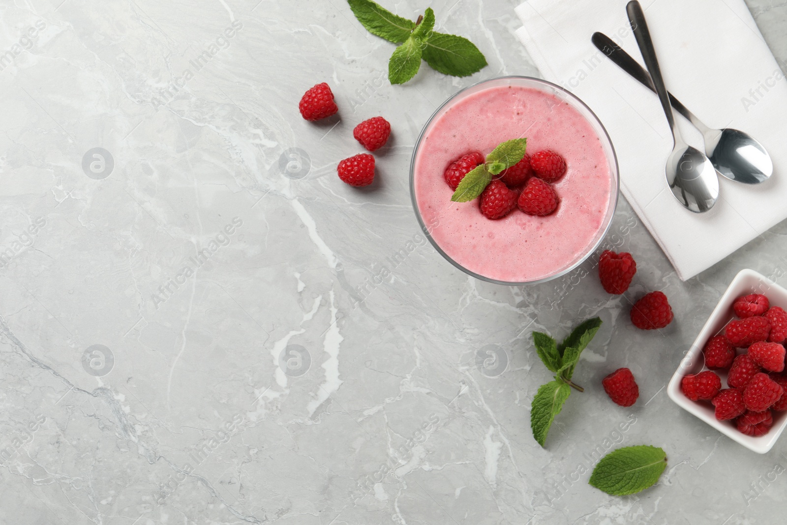 Photo of Delicious raspberry mousse with mint on grey marble table, flat lay. Space for text