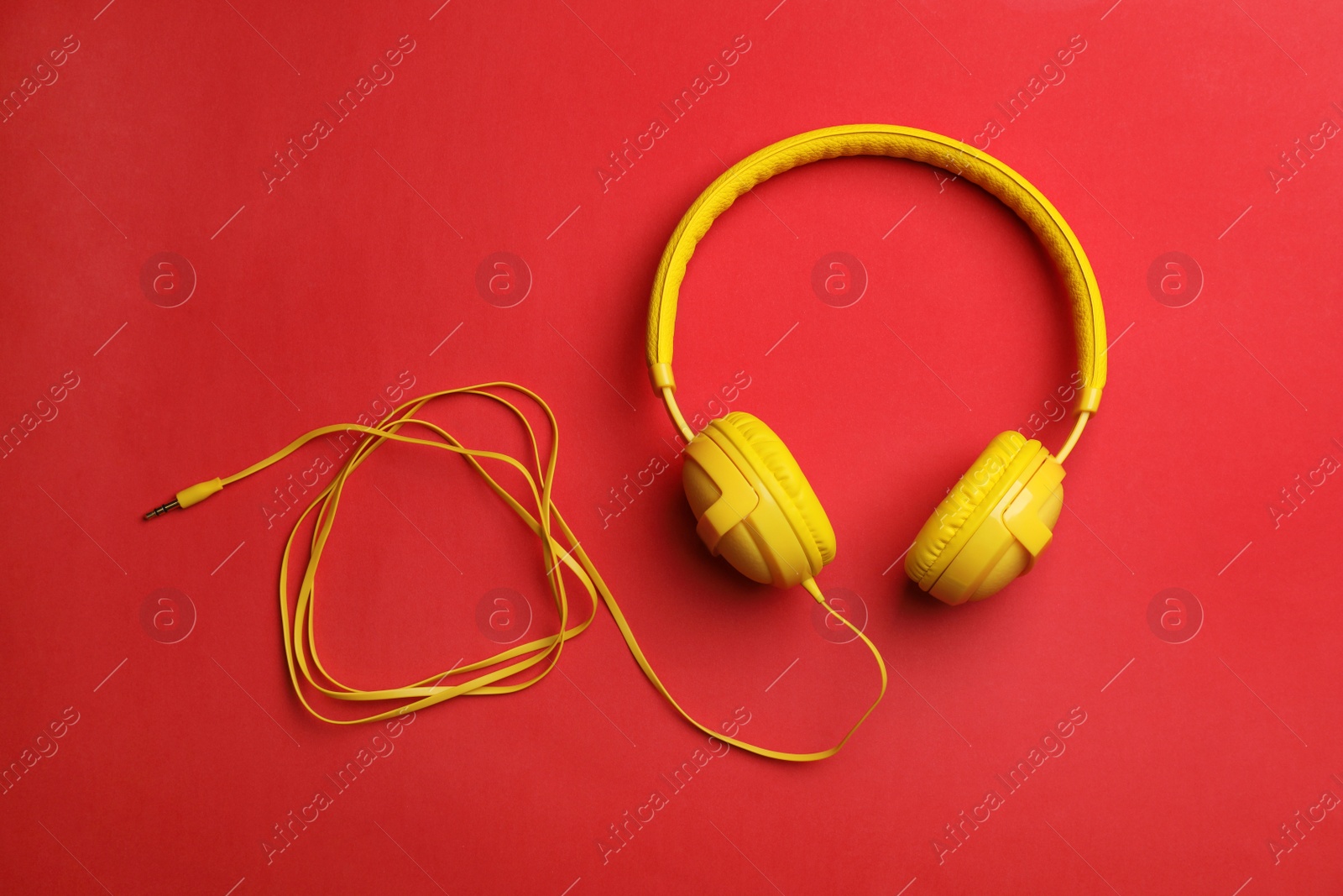 Photo of Stylish modern headphones with earmuffs on color background, top view