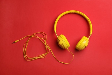 Photo of Stylish modern headphones with earmuffs on color background, top view