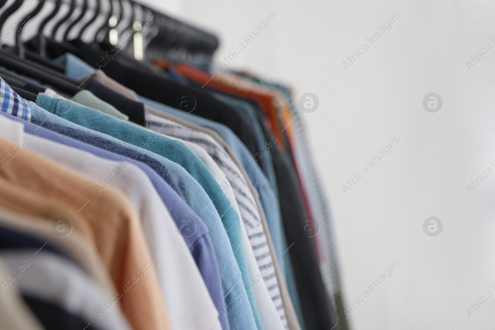 Photo of Rack with stylish clothes on white background, closeup. Fast fashion