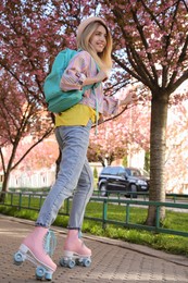 Photo of Young woman roller skating in spring park