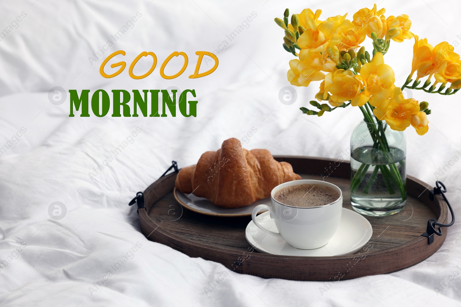 Image of Good Morning! Cup of coffee, croissant and flowers on bed