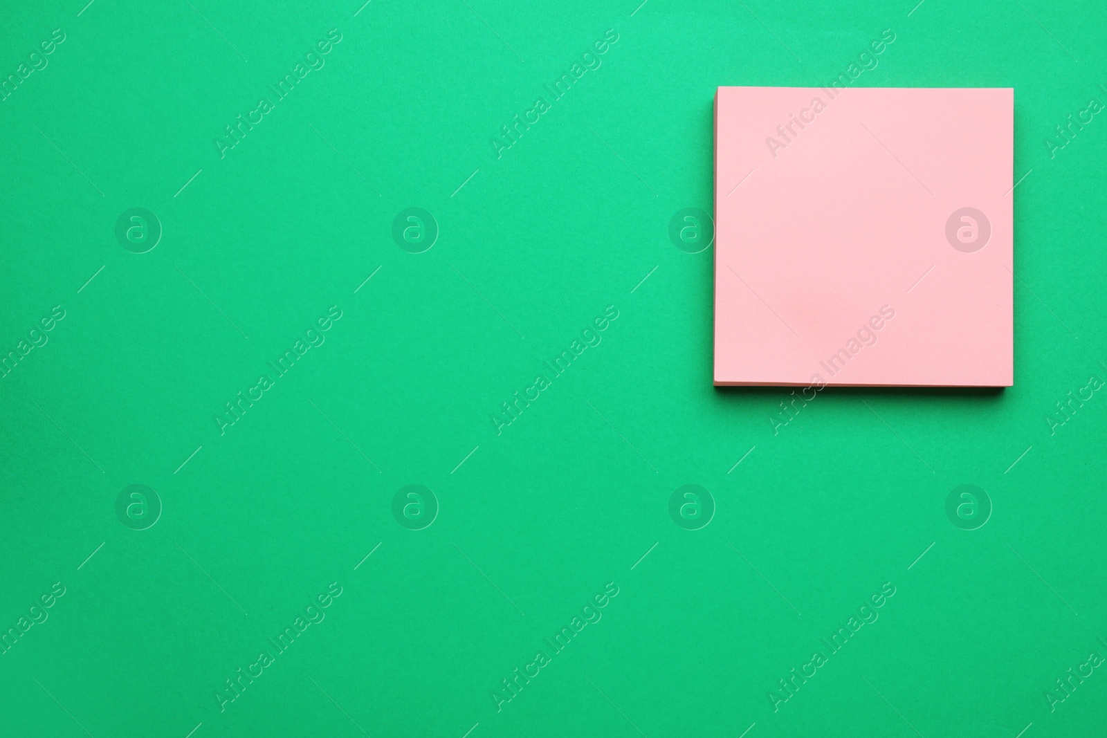 Photo of Empty notes on green background, top view. Space for text