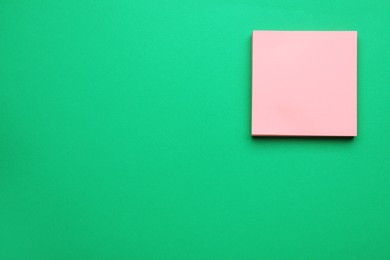 Photo of Empty notes on green background, top view. Space for text
