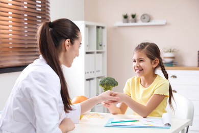 Little girl visiting professional nutritionist in office