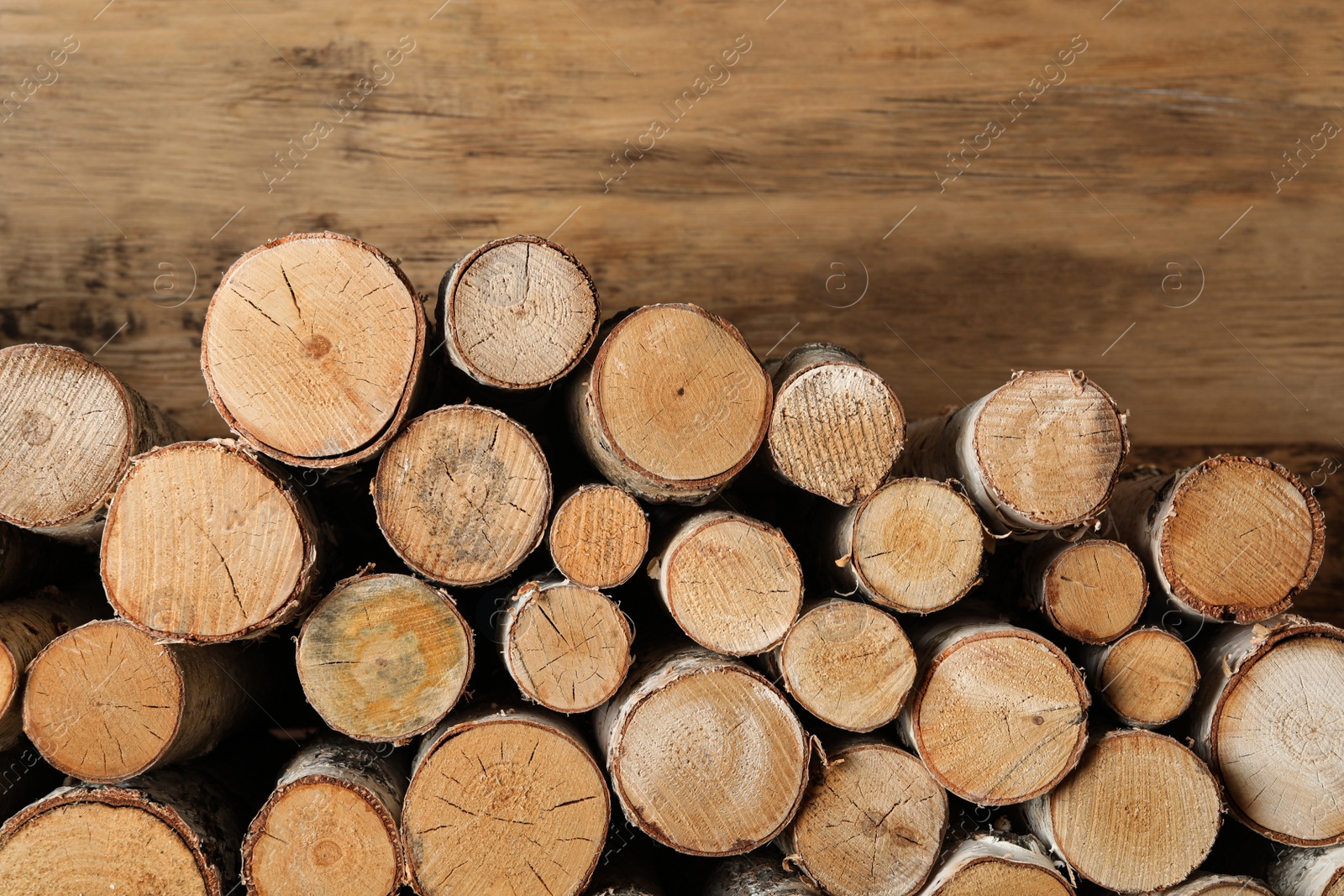 Photo of Cut firewood on wooden background. Heating in winter