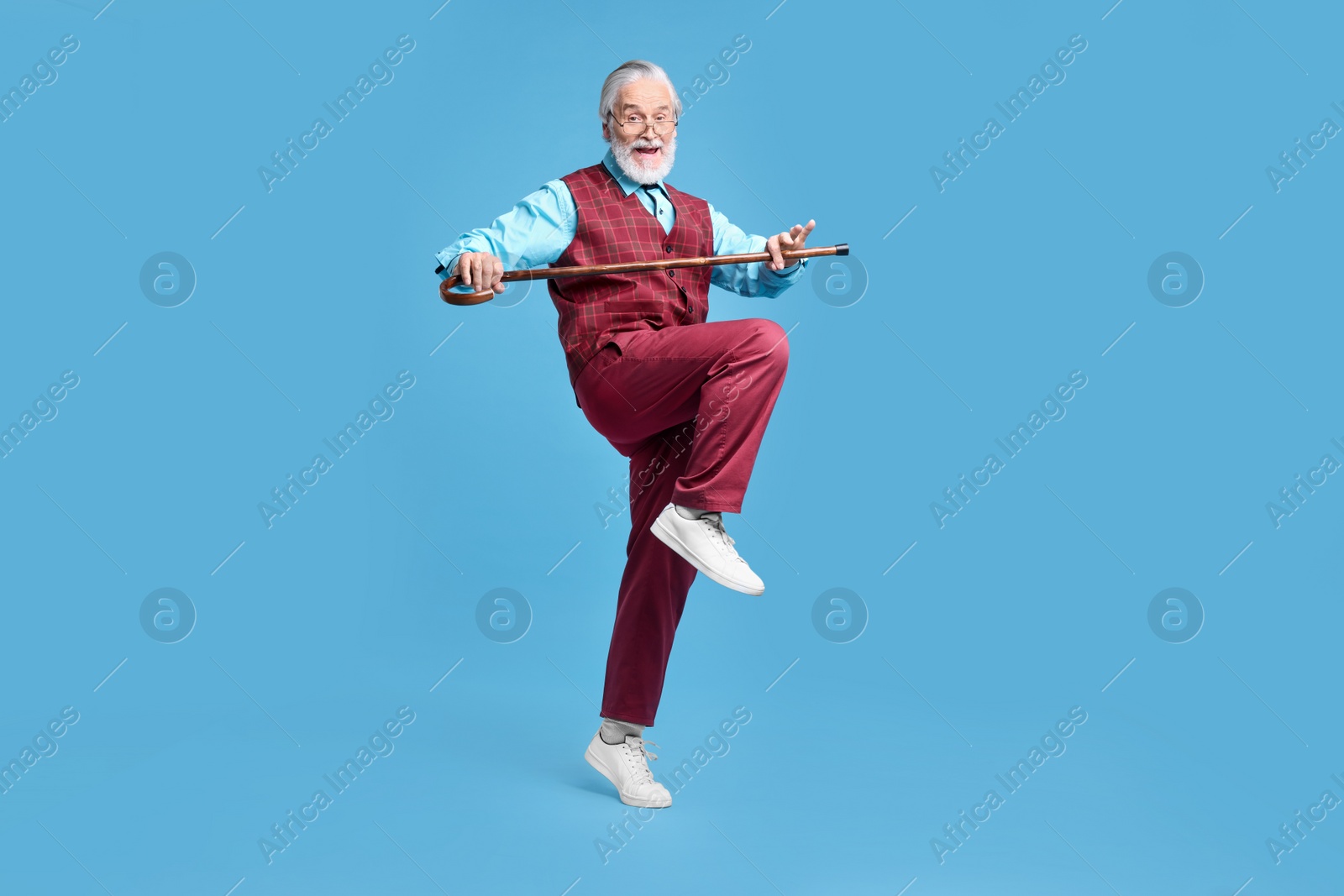 Photo of Emotional senior man with walking cane on light blue background