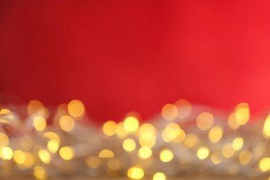 Photo of Blurred yellow Christmas lights against red background