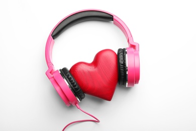 Photo of Decorative heart and modern headphones on white background, top view