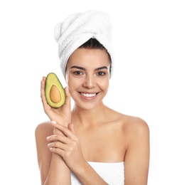 Photo of Happy young woman with towel holding avocado on white background. Organic face mask