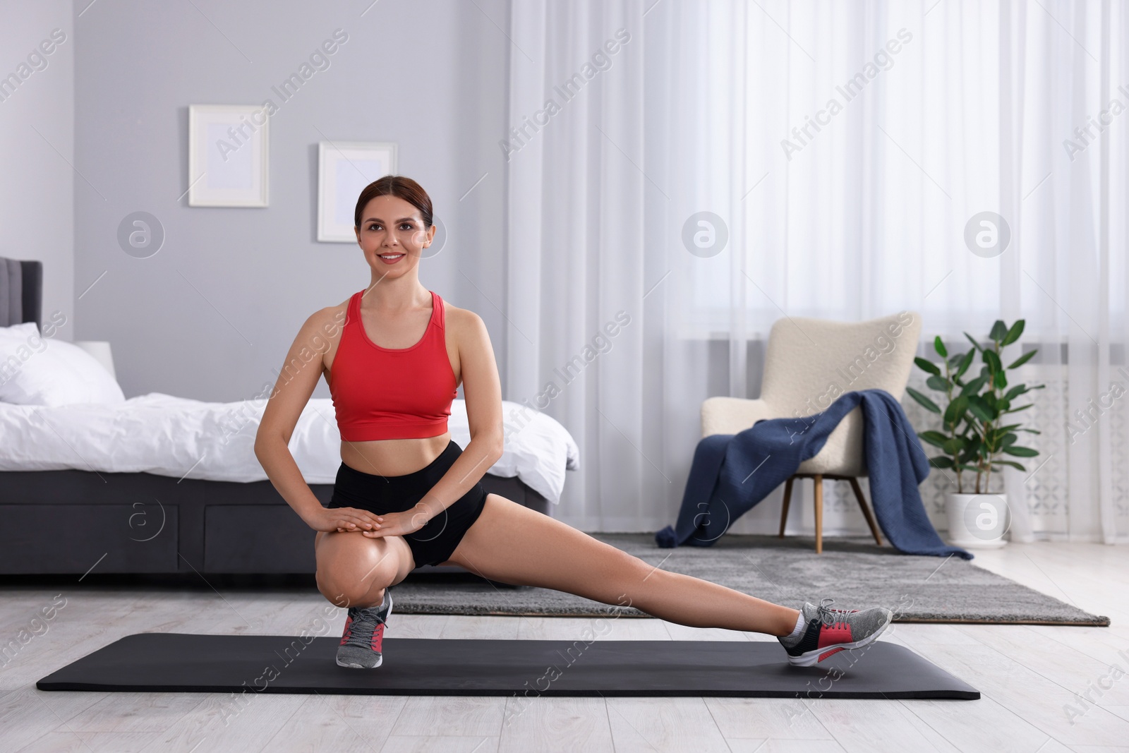 Photo of Morning routine. Happy woman doing stretching exercise at home, space for text