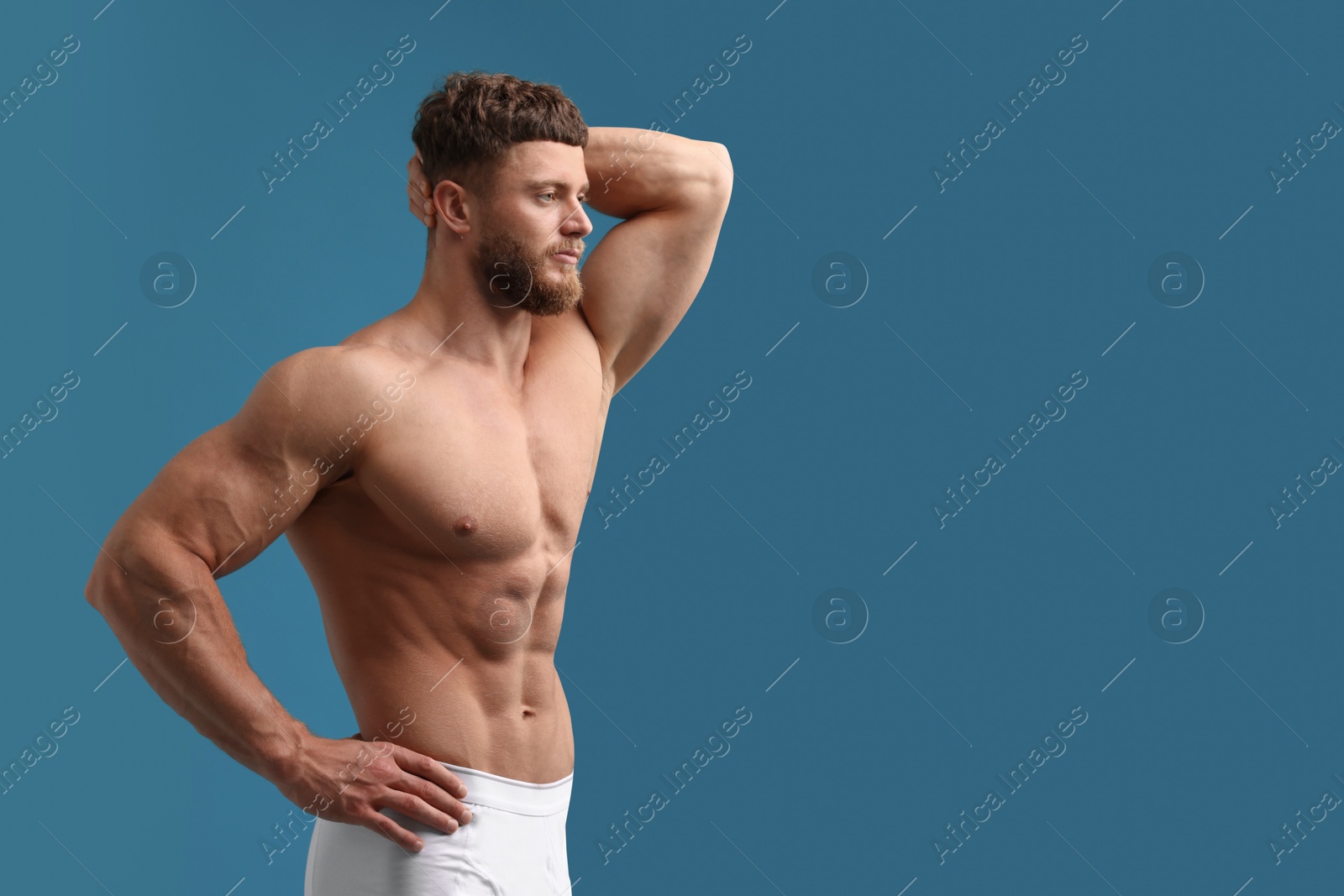 Photo of Handsome muscular man on light blue background, space for text. Sexy body