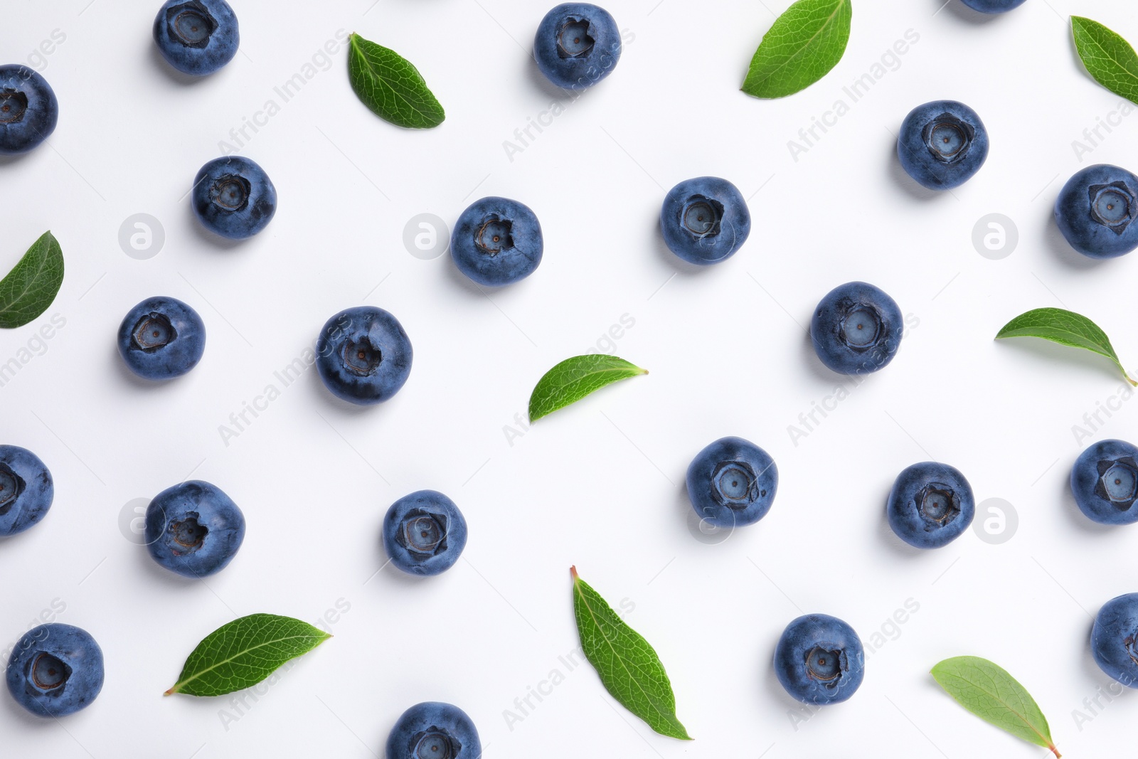 Photo of Tasty fresh blueberries with green leaves on white background, flat lay