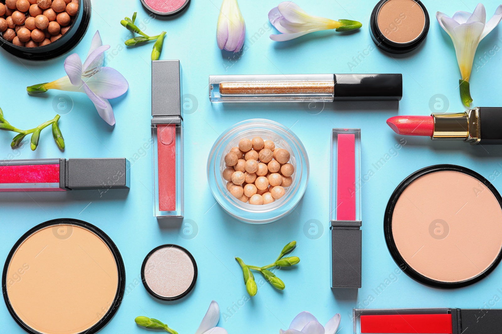 Photo of Makeup products and flowers on color background, flat lay