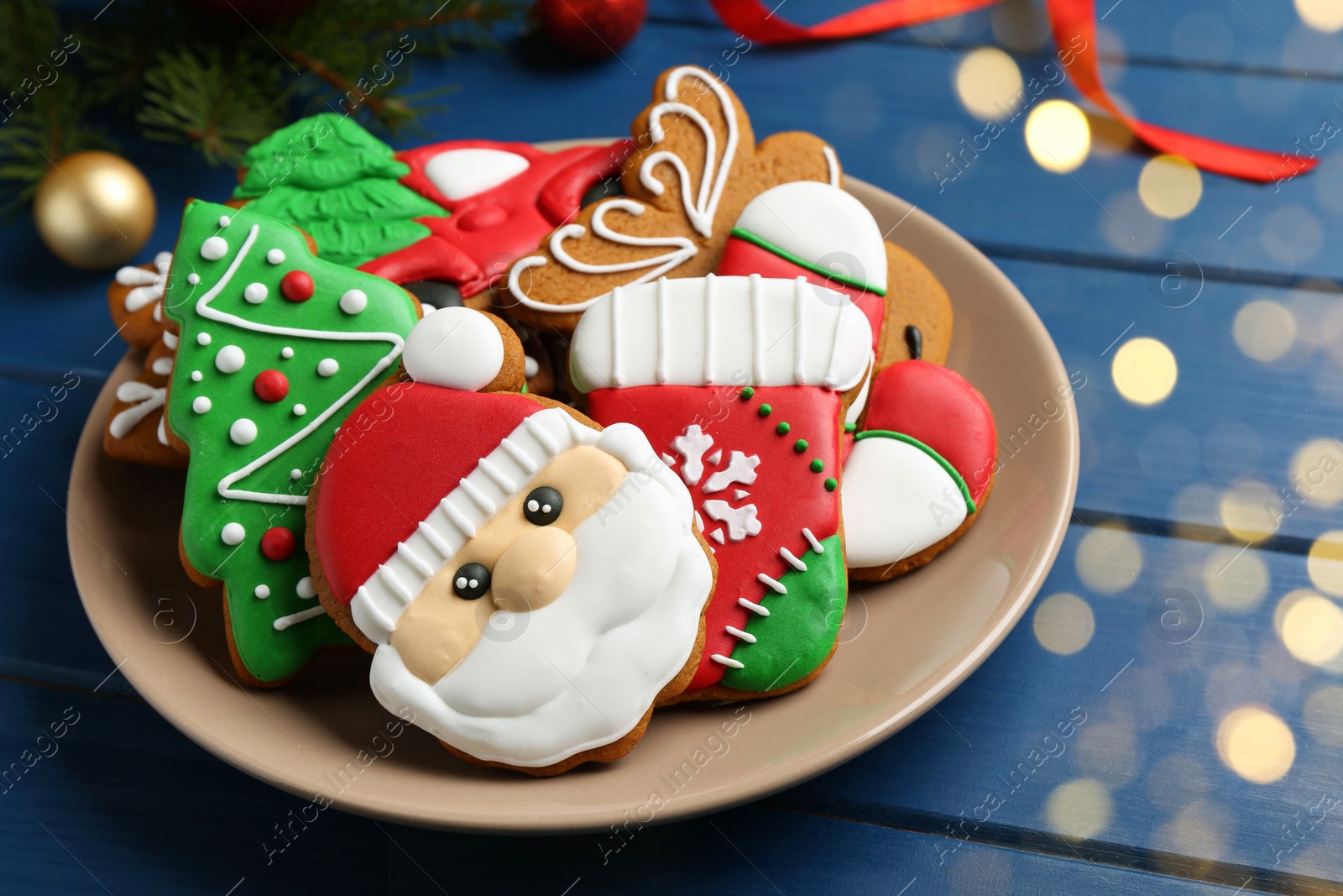 Photo of Different tasty Christmas cookies and decor on blue wooden table, closeup. Space for text