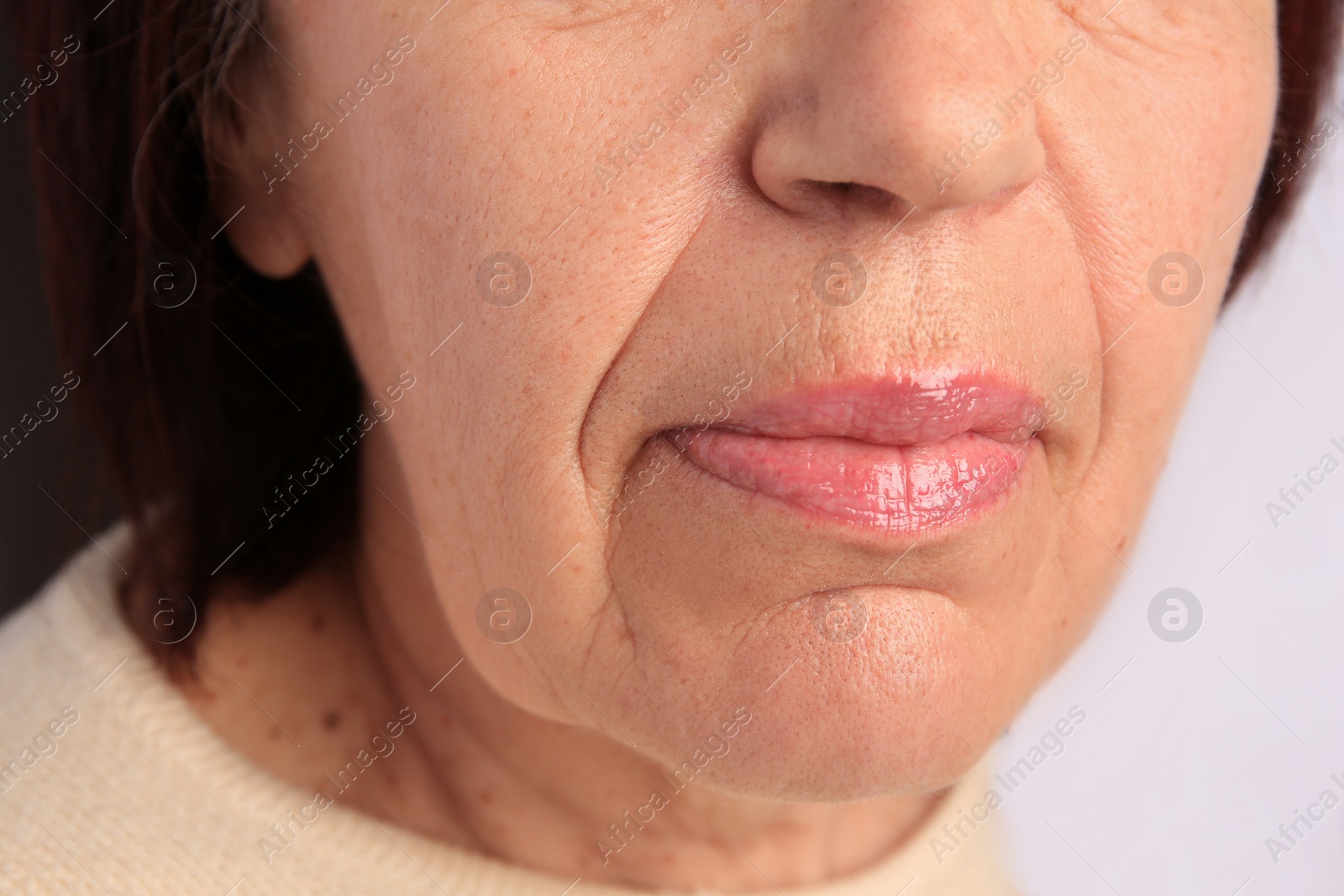 Photo of Closeup view of older woman on white background