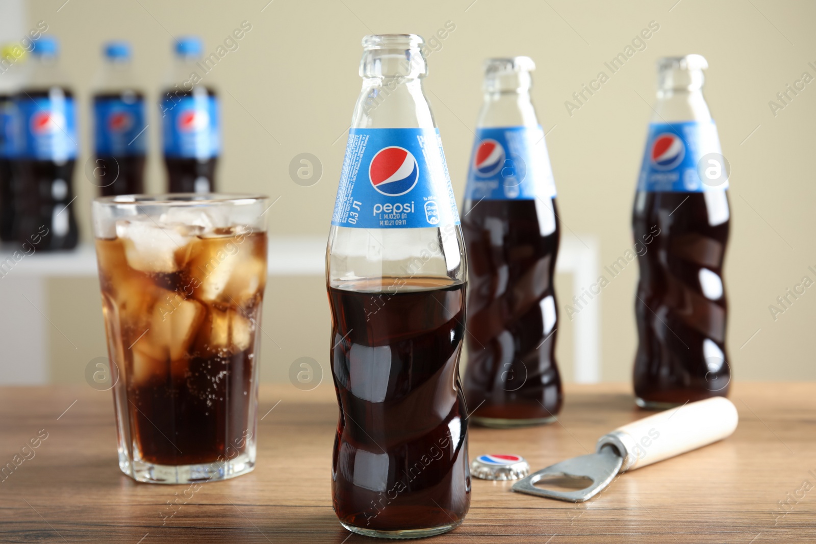 Photo of MYKOLAIV, UKRAINE - FEBRUARY 10, 2021: Bottles and glass of Pepsi on wooden table