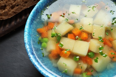 Bowl of fresh homemade vegetable soup on table, closeup