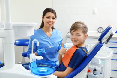 Photo of Professional dentist and little boy in clinic