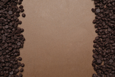 Delicious chocolate chips on brown background, top view. Space for text