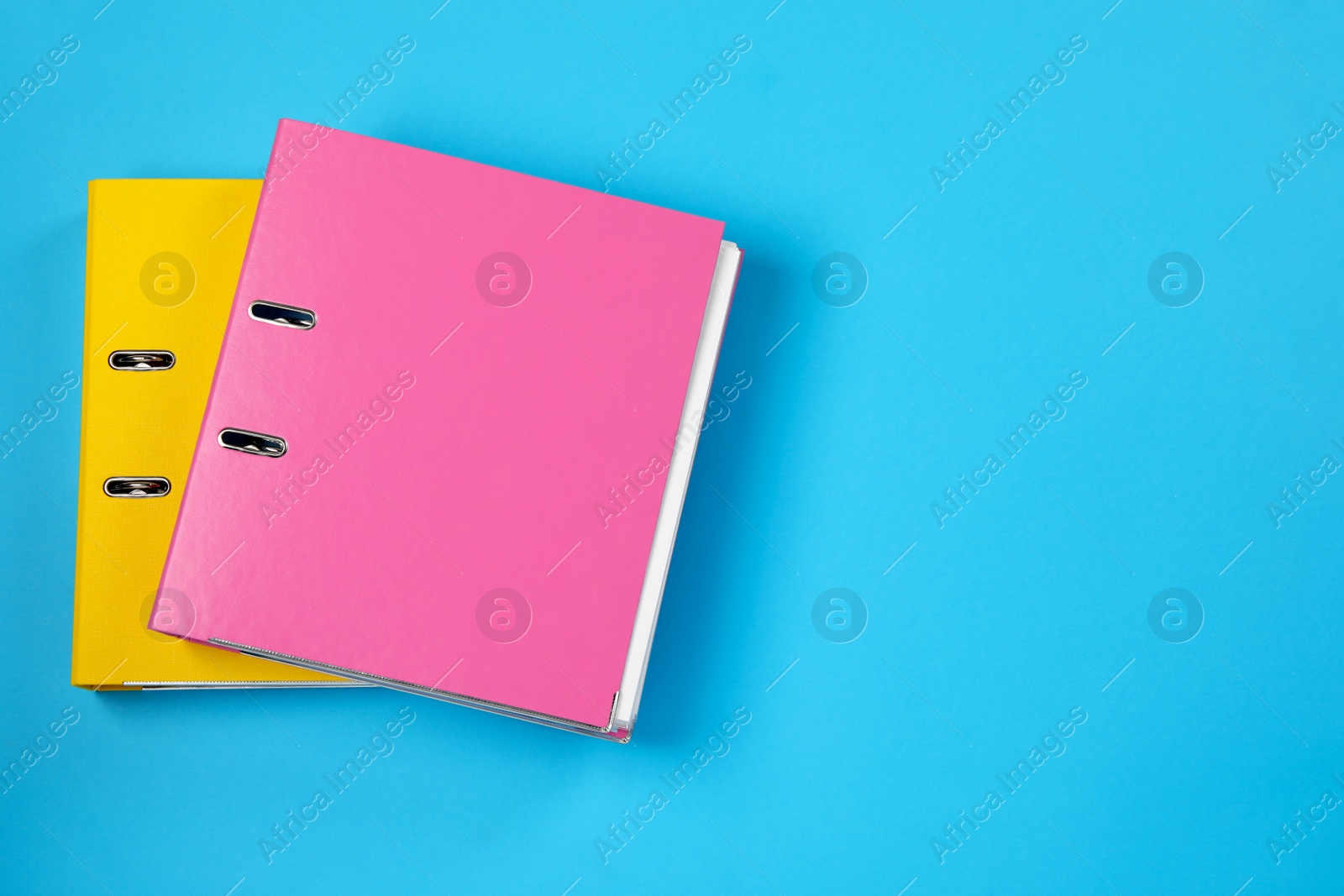 Photo of Office folders on light blue background, flat lay. Space for text