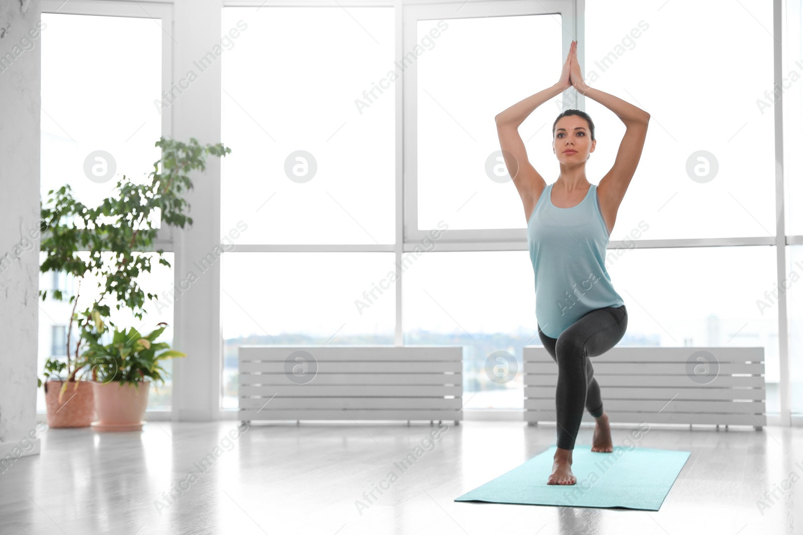 Photo of Young woman practicing crescent asana in yoga studio. High lunge pose