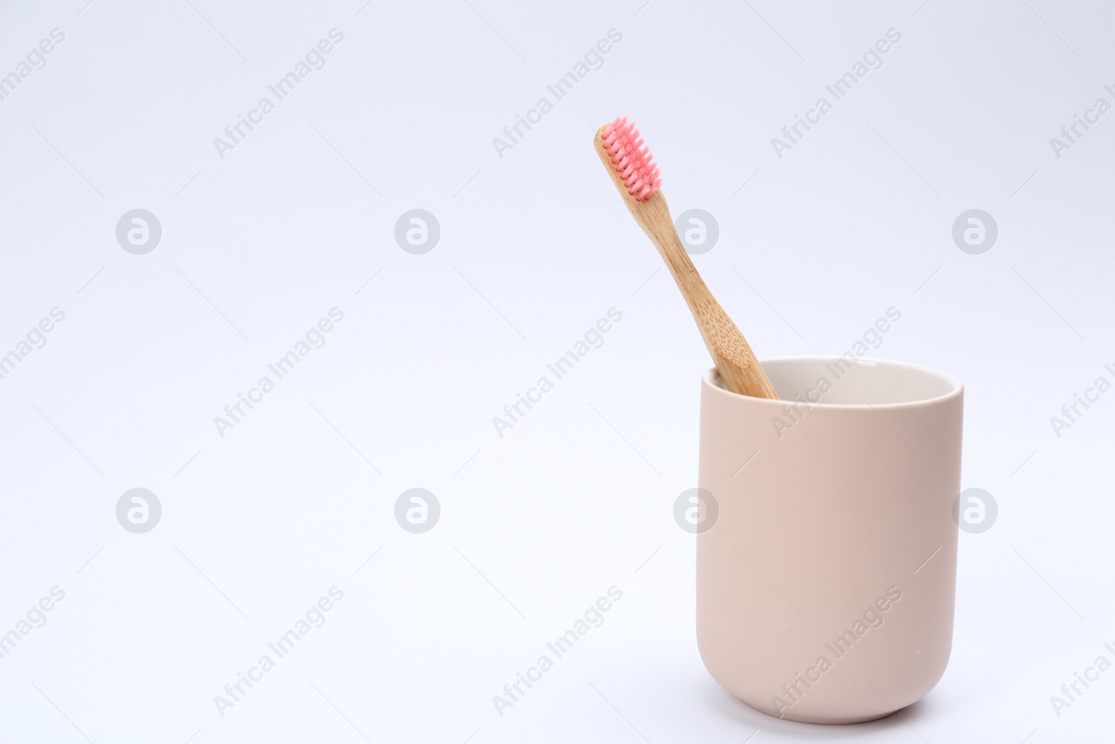 Photo of Bamboo toothbrush in holder isolated on white