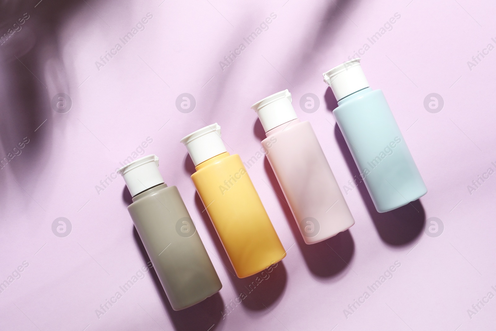 Photo of Cosmetic travel kit on violet background, top view